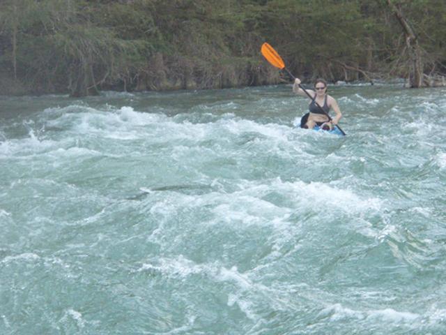 Kayaker paddling through whitewater on the Guadalupe River