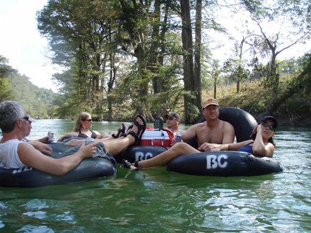 Group of friends floating in tubes