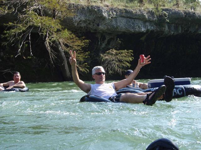 Tuber waving while floating the river